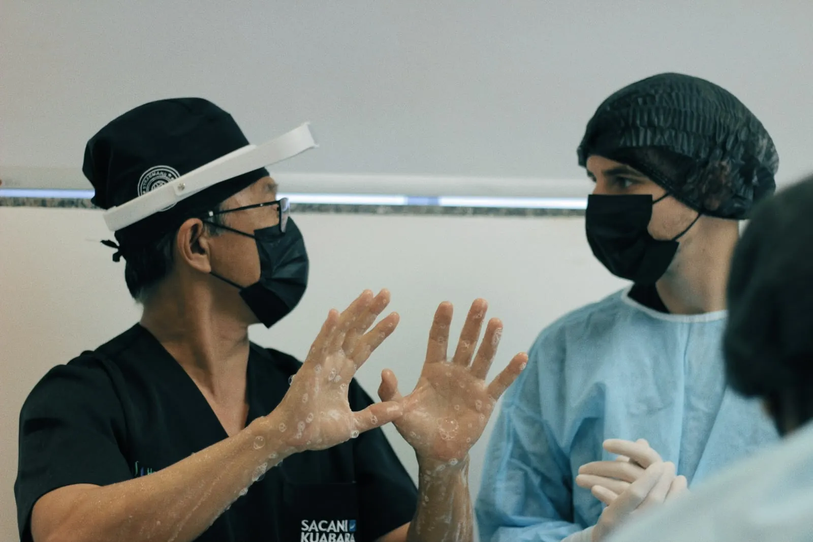 Dr. Kuabara guiding a mentee during surgical hand scrubbing