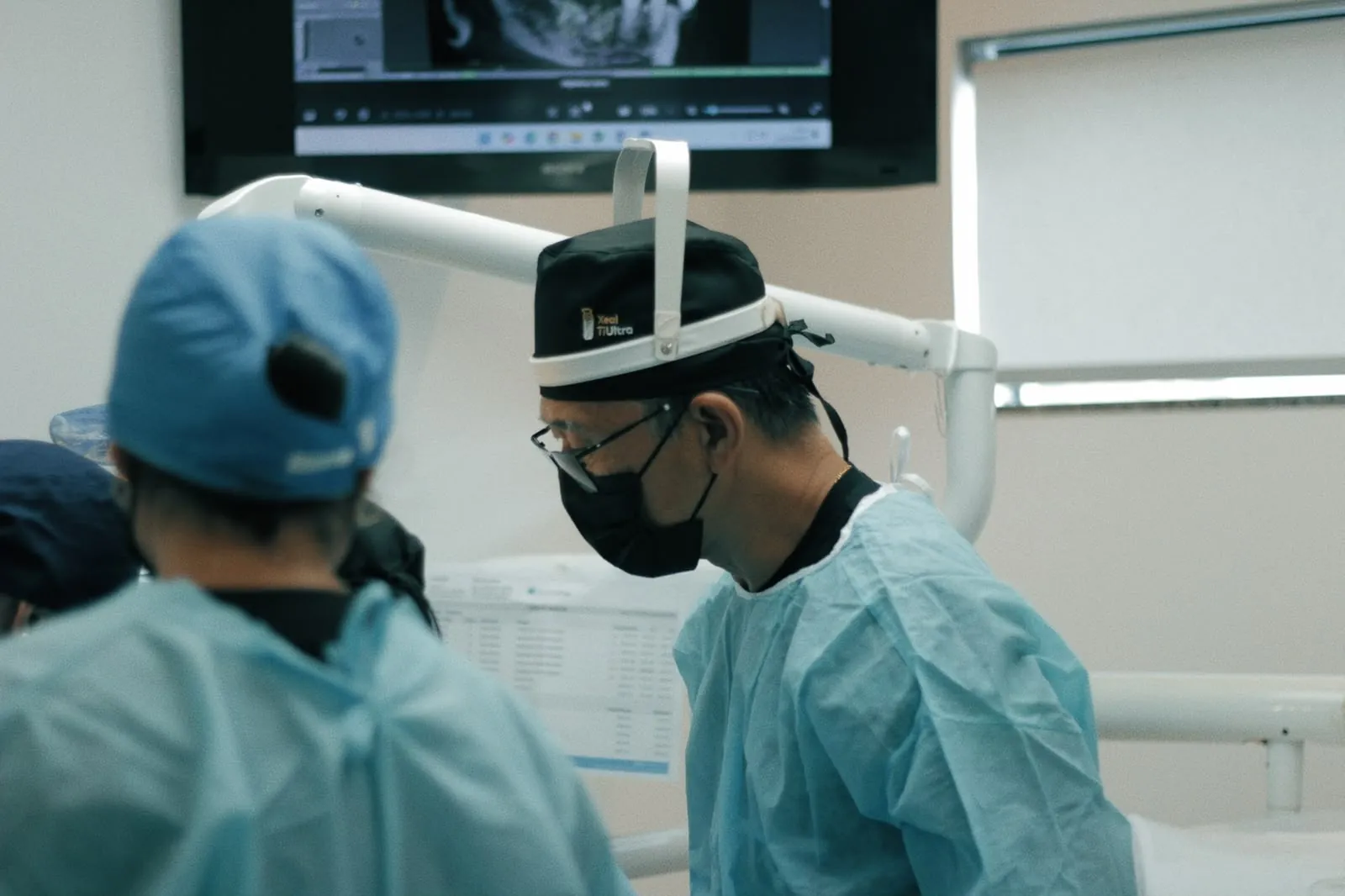 Dr. Kuabara reviewing a CT scan during surgery with mentees