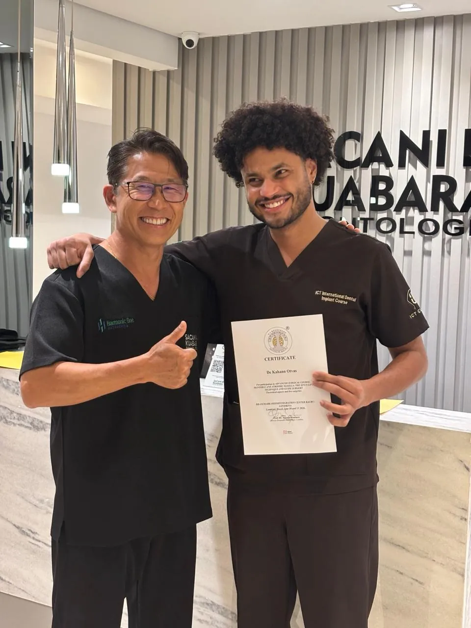 Dr. Kuabara congratulating a mentee with his certificate